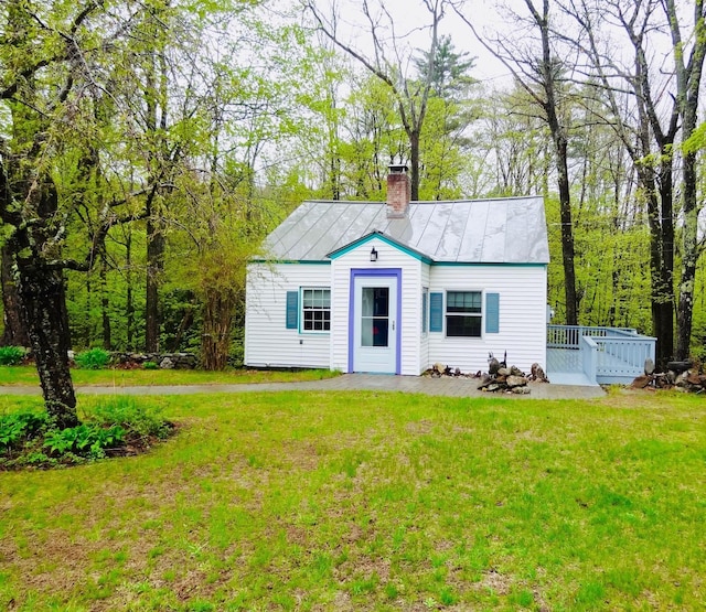 328 Main St Unit C, Andover, NH 03216 - view of front facade featuring a chimney, a front lawn, a deck, and metal roof