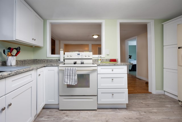 kitchen with electric range, light wood-style flooring, white cabinetry, and light stone counters
