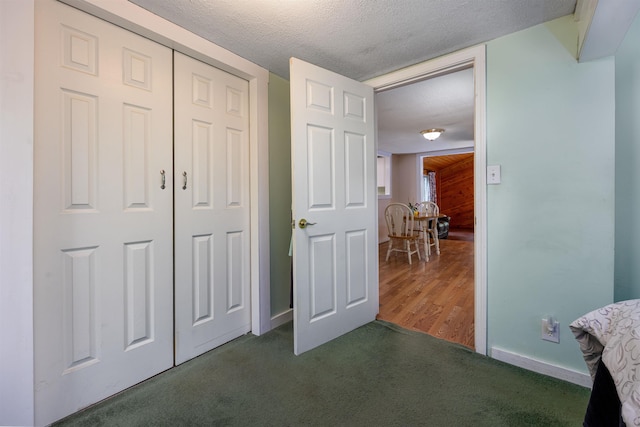 bedroom featuring carpet, a textured ceiling, a closet, and baseboards