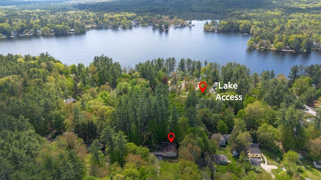 aerial view of property and surrounding area with a forest and a large body of water