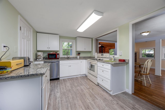 kitchen featuring white range with electric stovetop, stainless steel dishwasher, light wood-style flooring, white cabinets, and a sink