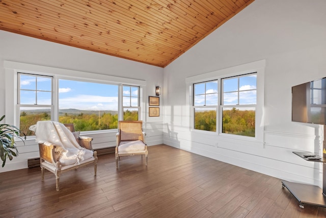 living area featuring high vaulted ceiling, a wainscoted wall, wood finished floors, and wood ceiling