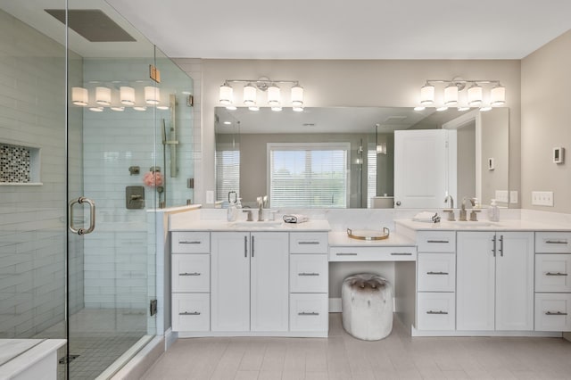 full bath with a stall shower and two vanities