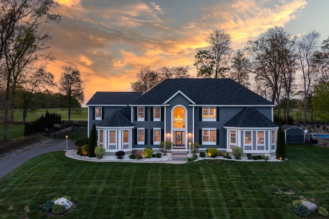 view of front of home featuring a yard and a shingled roof