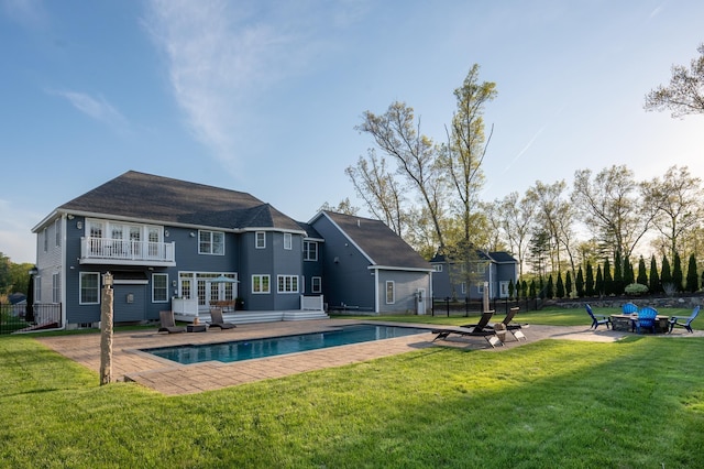 rear view of property featuring an outdoor fire pit, an outdoor pool, and a patio