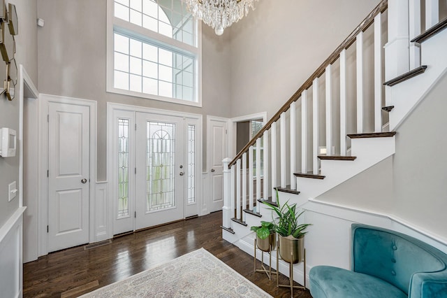 entrance foyer featuring a high ceiling, a chandelier, stairway, and wood finished floors