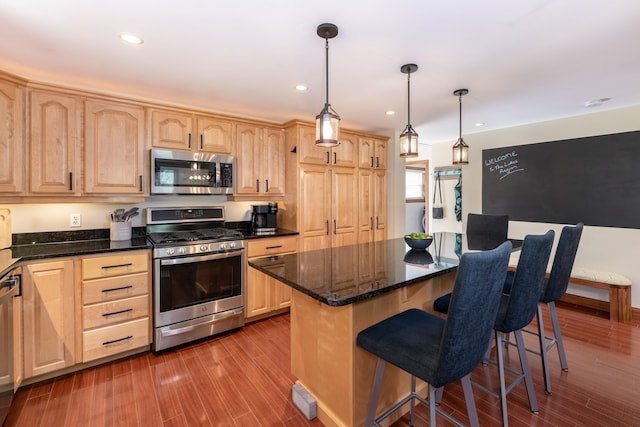 49 Hayes Rd, Laconia, NH 03246 - kitchen with stainless steel appliances, light brown cabinets, a kitchen bar, wood finished floors, and recessed lighting