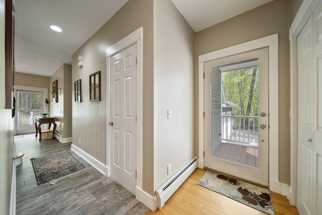 32 Wellesley Dr, Bedford, NH 03110 - entryway with a baseboard radiator, healthy amount of natural light, wood finished floors, and baseboards
