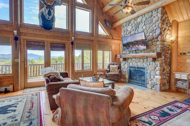1481 Eaton Rd, Conway, NH 03813 - living area with high vaulted ceiling, wood-type flooring, wood ceiling, a stone fireplace, and wooden walls