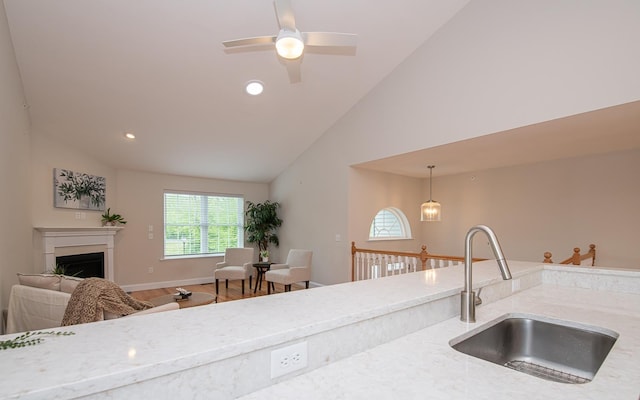 41 Winchester Dr, Hampstead, NH 03826 - kitchen with a sink, light stone countertops, high vaulted ceiling, a fireplace, and a ceiling fan