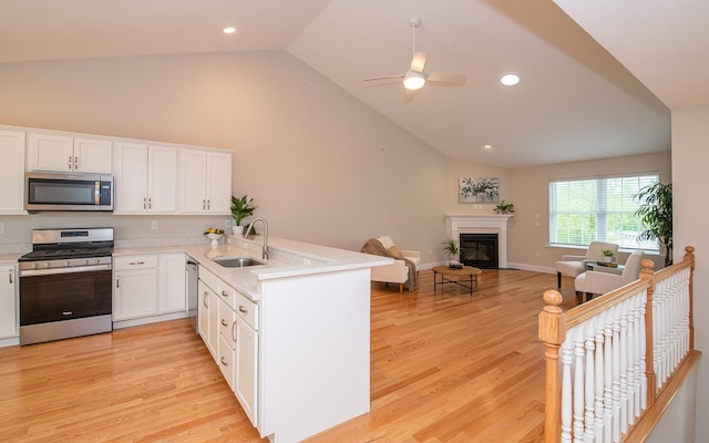 41 Winchester Dr, Hampstead, NH 03826 - kitchen featuring appliances with stainless steel finishes, a sink, vaulted ceiling, white cabinets, and a peninsula