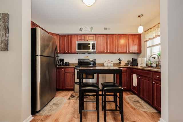 11 Sullivan Way Unit 6, Laconia, NH 03246 - kitchen with appliances with stainless steel finishes, a sink, light wood-style floors, and dark stone counters