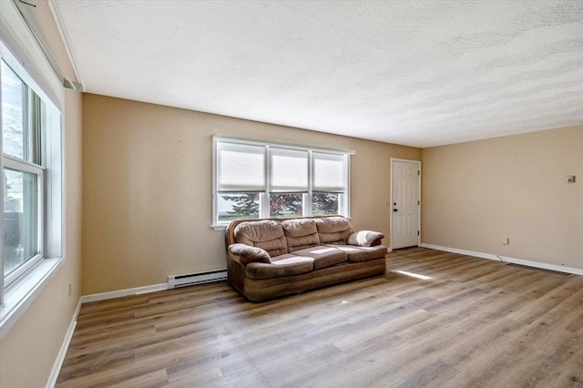 2099 W Shore Rd, Alburgh, VT 05440 - living area with a baseboard heating unit, a textured ceiling, plenty of natural light, light wood-style floors, and baseboards