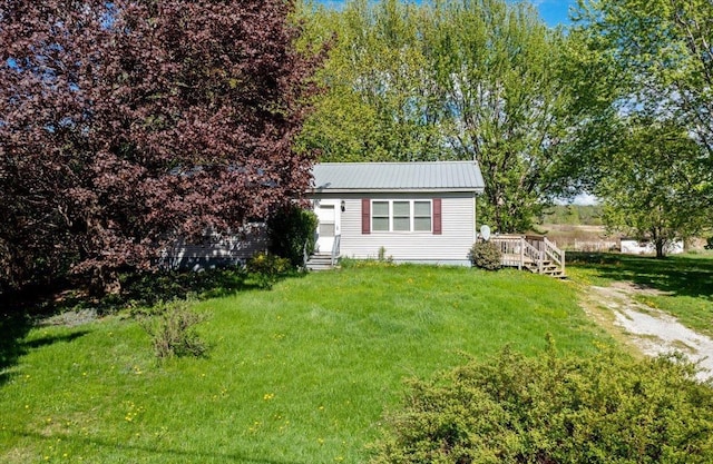 2099 W Shore Rd, Alburgh, VT 05440 - view of front of house with entry steps, a front yard, a deck, and metal roof