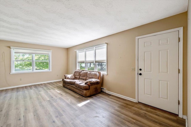 2099 W Shore Rd, Alburgh, VT 05440 - living area with wood finished floors, baseboards, a textured ceiling, and a baseboard radiator