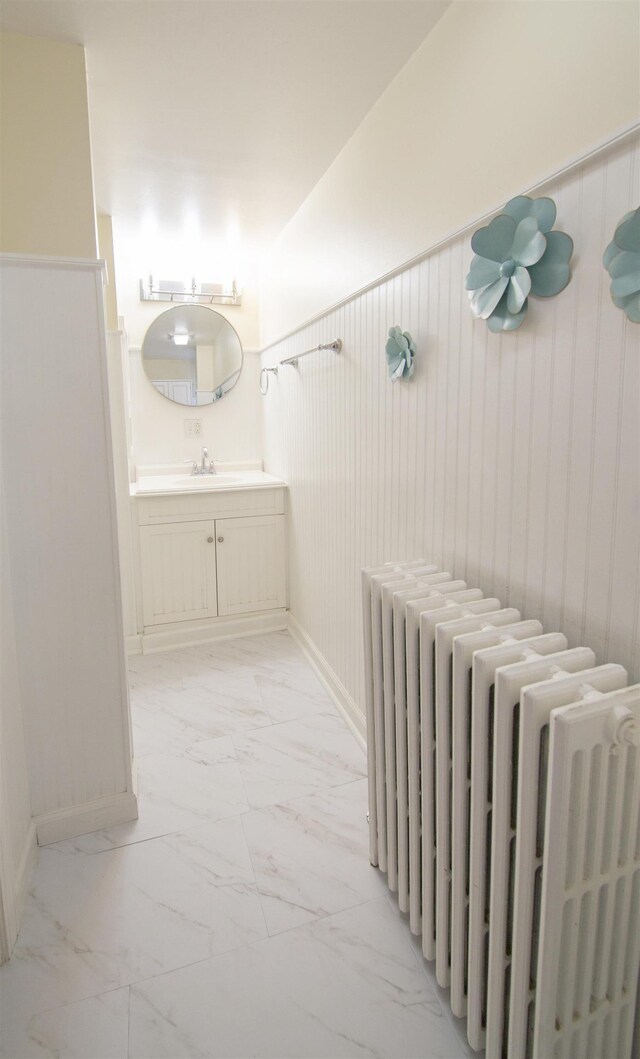 47 Pitkin St, Burlington, VT 05401 - bathroom with radiator, marble look tile flooring, vanity, and baseboards