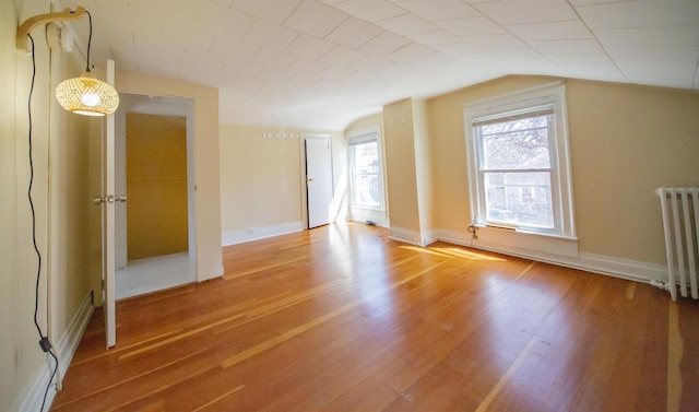 47 Pitkin St, Burlington, VT 05401 - spare room featuring radiator heating unit, wood finished floors, vaulted ceiling, and baseboards