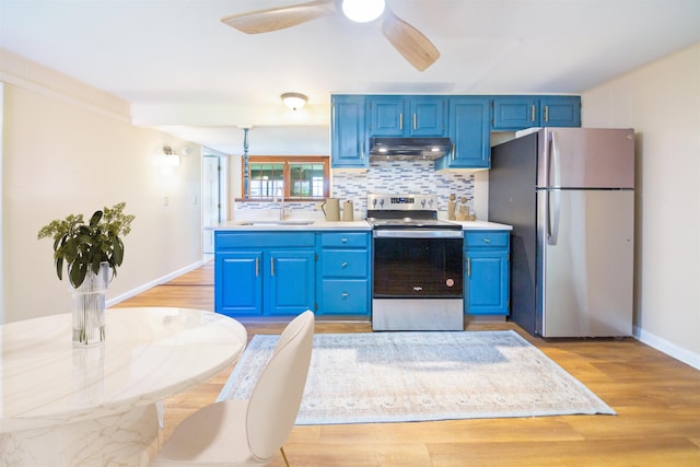 47 Pitkin St, Burlington, VT 05401 - kitchen featuring stainless steel appliances, a sink, blue cabinets, under cabinet range hood, and light countertops