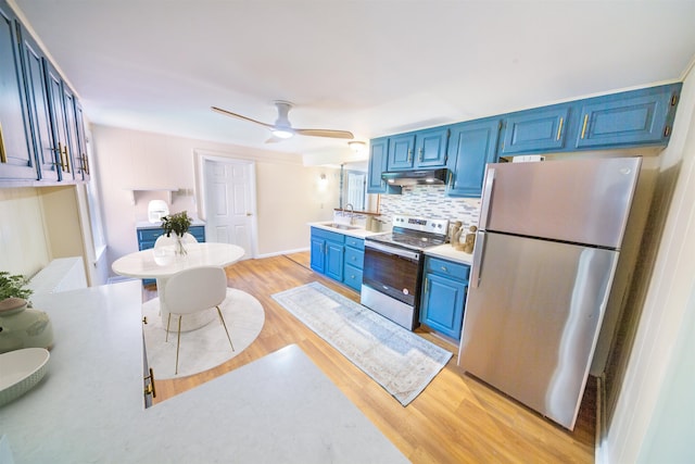 47 Pitkin St, Burlington, VT 05401 - kitchen with stainless steel appliances, blue cabinets, under cabinet range hood, a sink, and light wood-style flooring