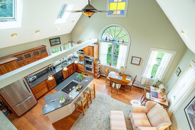 685 Abbot Hill Rd, Wilton, NH 03086 - living room with high vaulted ceiling, a skylight, light wood-style flooring, baseboard heating, and recessed lighting