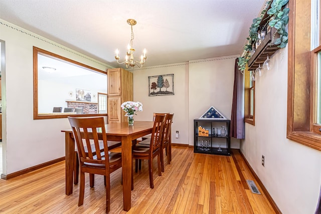 dining room featuring a chandelier, light wood-style flooring, and baseboards
