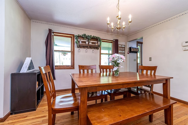 dining room with light wood-style floors, a chandelier, and baseboards