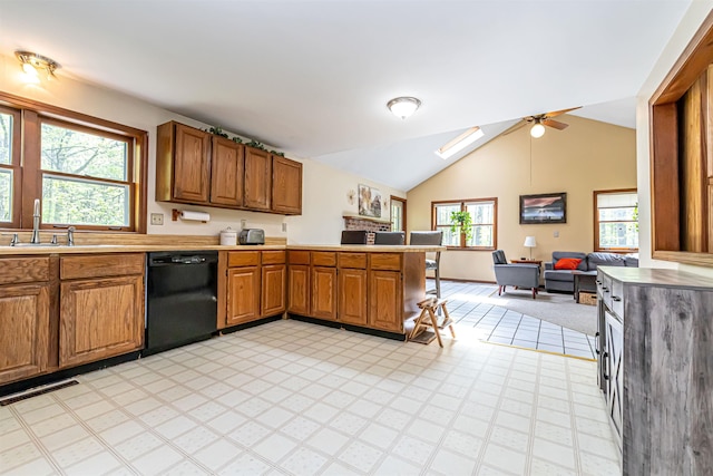 kitchen with dishwasher, a sink, a peninsula, brown cabinets, and light countertops