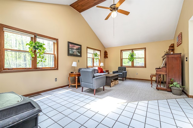living room featuring baseboards, a ceiling fan, high vaulted ceiling, light colored carpet, and light tile patterned floors
