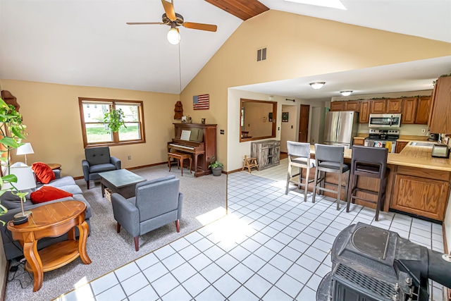living room with a ceiling fan, high vaulted ceiling, and baseboards