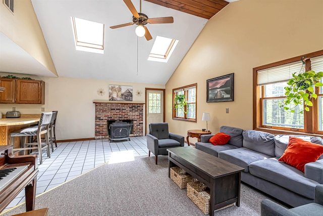 living area with a skylight, healthy amount of natural light, a ceiling fan, high vaulted ceiling, and light tile patterned floors