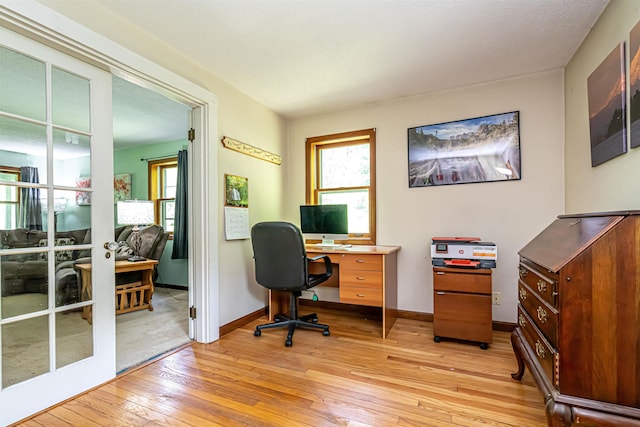 office space with light wood-type flooring and baseboards