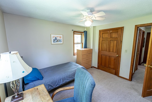 bedroom featuring carpet, a textured ceiling, and a ceiling fan