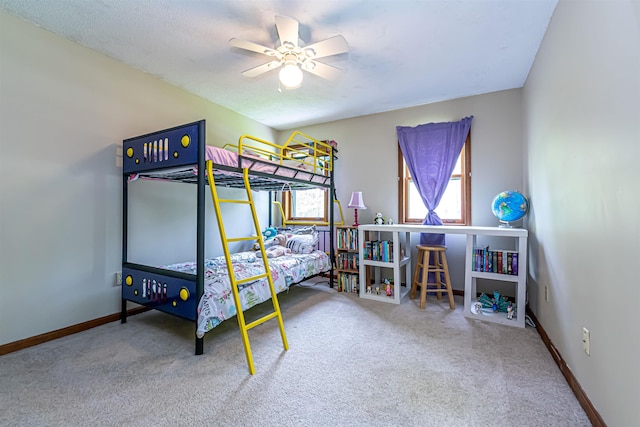 carpeted bedroom featuring baseboards and ceiling fan