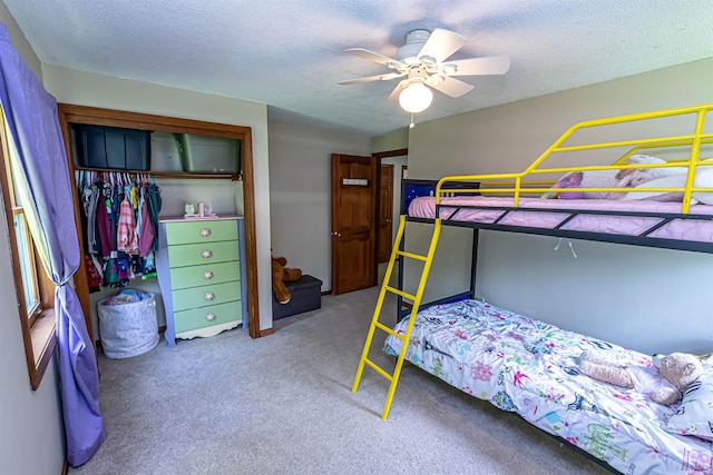 bedroom featuring a closet, carpet floors, a textured ceiling, and a ceiling fan