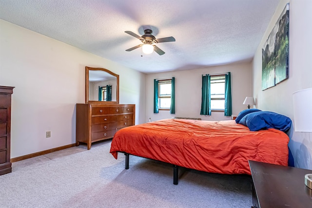 bedroom featuring a textured ceiling, carpet flooring, ceiling fan, and baseboards