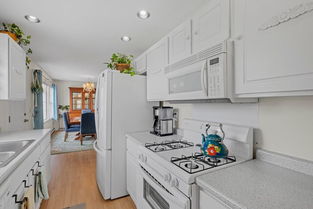 28 Lindsley Cir, Campton, NH 03223 - kitchen featuring white appliances, light wood finished floors, white cabinets, a chandelier, and light countertops