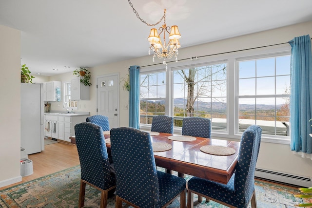 28 Lindsley Cir, Campton, NH 03223 - dining area with a baseboard radiator, a chandelier, and light wood-style floors