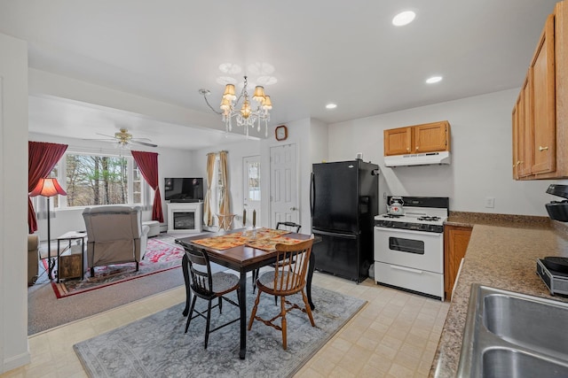 28 Lindsley Cir, Campton, NH 03223 - kitchen with white range with gas cooktop, freestanding refrigerator, a sink, under cabinet range hood, and ceiling fan
