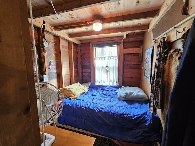 bedroom with beamed ceiling, wooden walls, and wooden ceiling