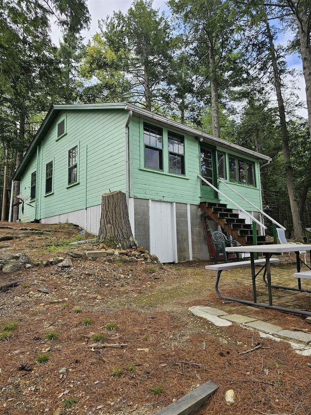 view of home's exterior featuring stairway and a sunroom