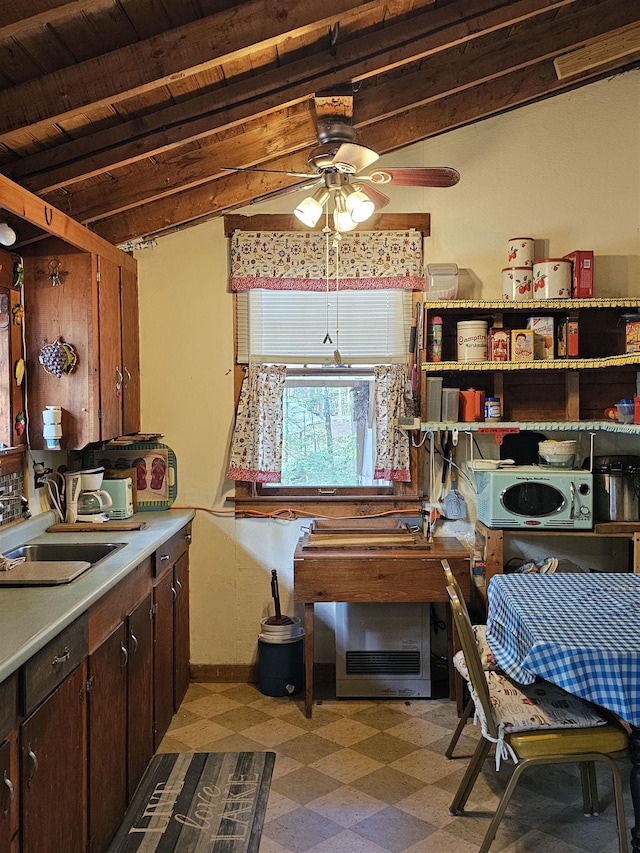 kitchen with light flooring, ceiling fan, wooden ceiling, a sink, and dark brown cabinetry