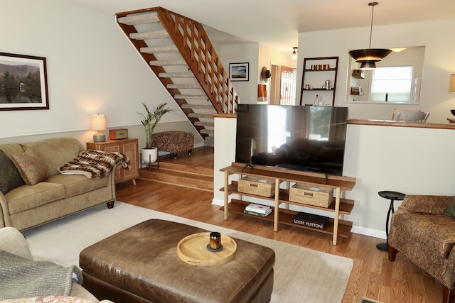 living room with stairs and wood finished floors