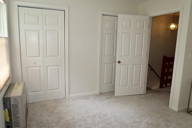 unfurnished bedroom featuring carpet floors, two closets, and baseboards