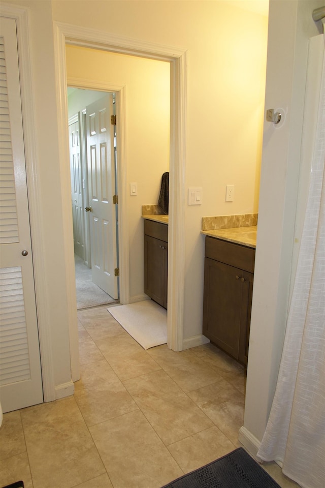 bathroom featuring vanity, tile patterned flooring, and baseboards