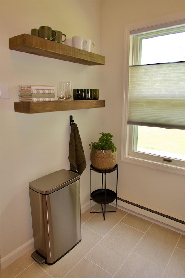 doorway featuring a baseboard radiator, baseboards, and light tile patterned floors