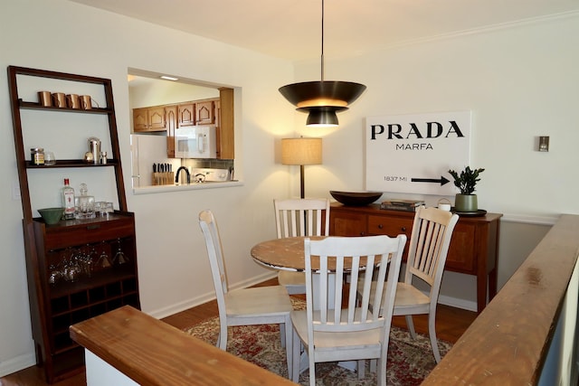 dining room with dark wood-style flooring and baseboards
