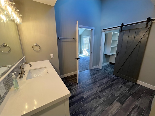 80 Mill St, Conway, NH 03813 - bathroom with baseboards, wood tiled floors, vanity, and a high ceiling