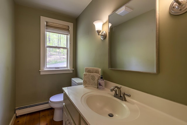 258 Densmore Hill Rd, Hartland, VT 05048 - half bath with baseboard heating, toilet, vanity, wood finished floors, and baseboards