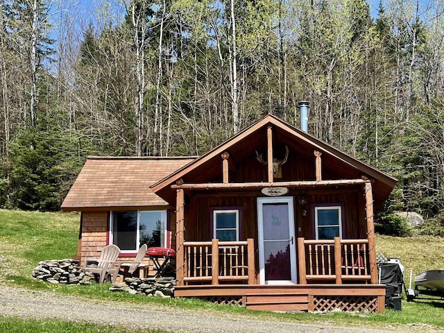 52 Timberland Rd, Pittsburg, NH 03592 - view of front of property with a porch, a view of trees, and board and batten siding