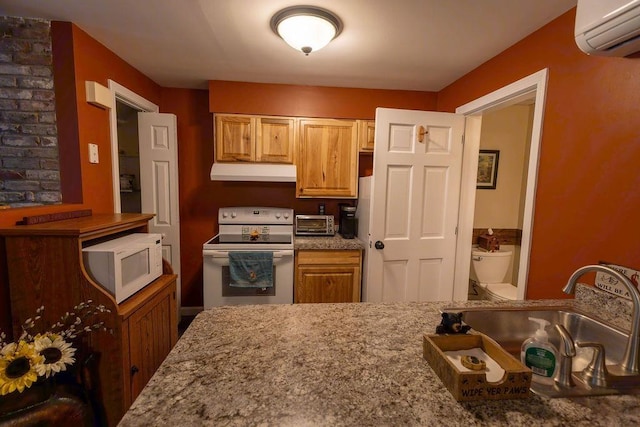 125 Washington Rd Unit 59, Freedom, NH 03836 - kitchen featuring white appliances, a wall unit AC, under cabinet range hood, a sink, and light stone counters
